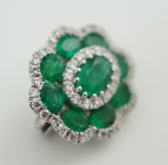 A mid to late 20th century white gold, emerald and diamond cluster set brooch